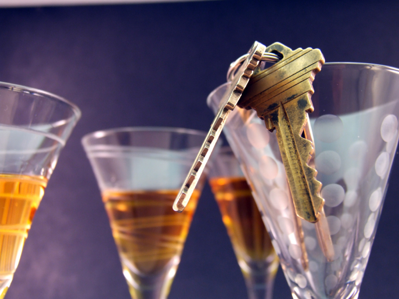 keys hanging on top of glasses with alcohol